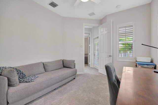 carpeted office space featuring ceiling fan