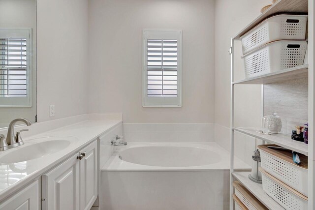 bathroom featuring vanity and a bath