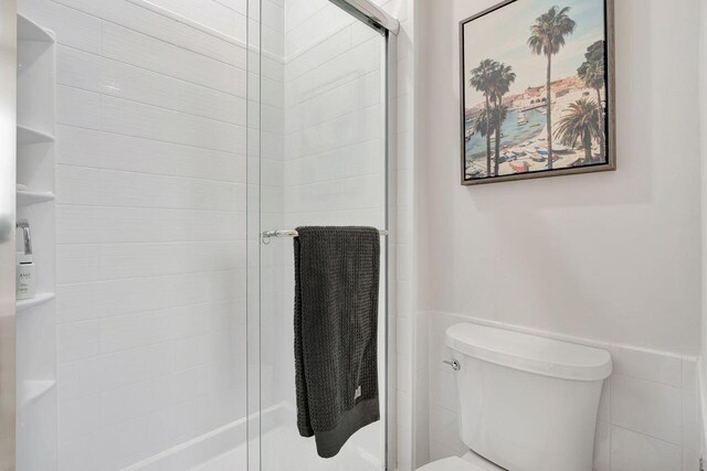 bathroom featuring toilet and an enclosed shower