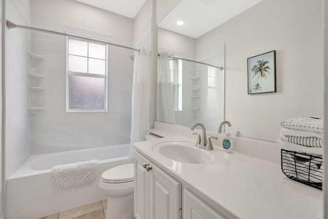 full bathroom featuring tile patterned floors, vanity, toilet, and shower / bath combo