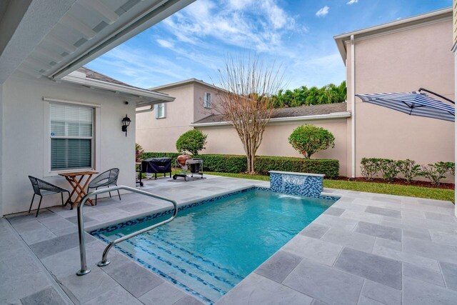 view of pool with pool water feature and a patio area