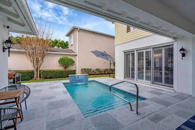 view of swimming pool featuring pool water feature and a patio area