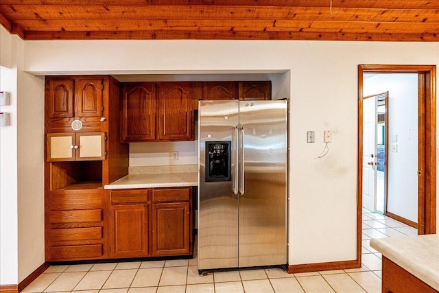 kitchen with light tile patterned flooring, wood ceiling, and stainless steel fridge