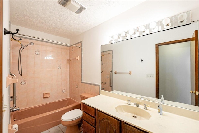 full bathroom with tile patterned flooring, tiled shower / bath combo, toilet, vanity, and a textured ceiling