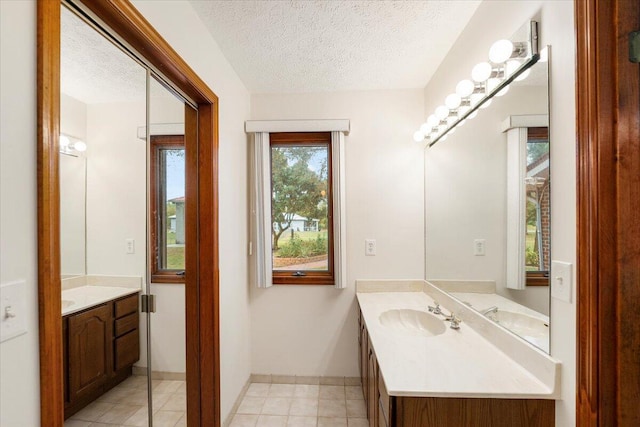 bathroom featuring a textured ceiling, tile patterned floors, and vanity