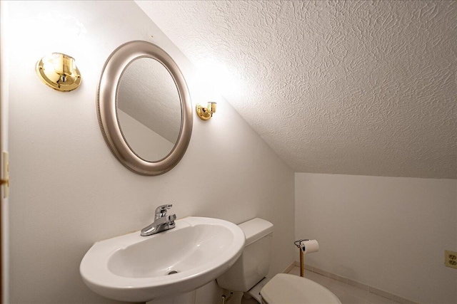 bathroom featuring sink, lofted ceiling, a textured ceiling, and toilet