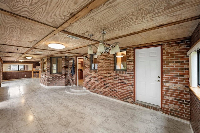 interior space with brick wall and a notable chandelier