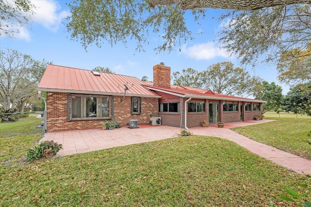 back of house with a lawn and a patio area