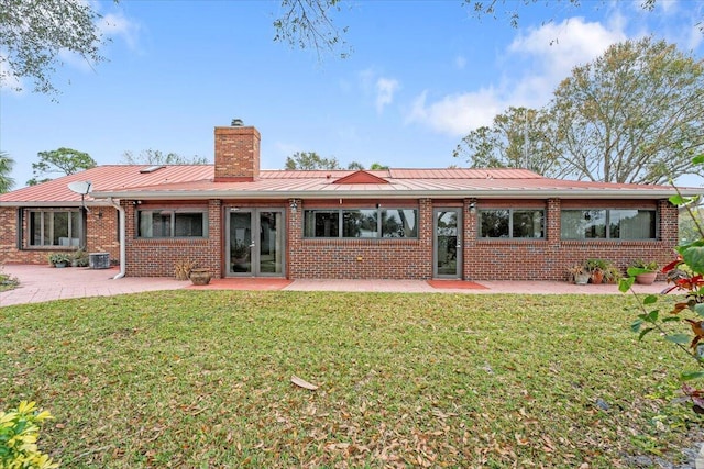 back of house featuring cooling unit, a patio area, french doors, and a lawn