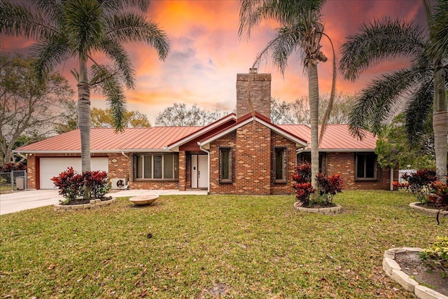 ranch-style house with a yard and a garage