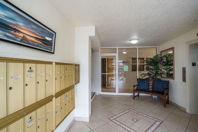 hall featuring mail boxes, a textured ceiling, and light tile patterned floors