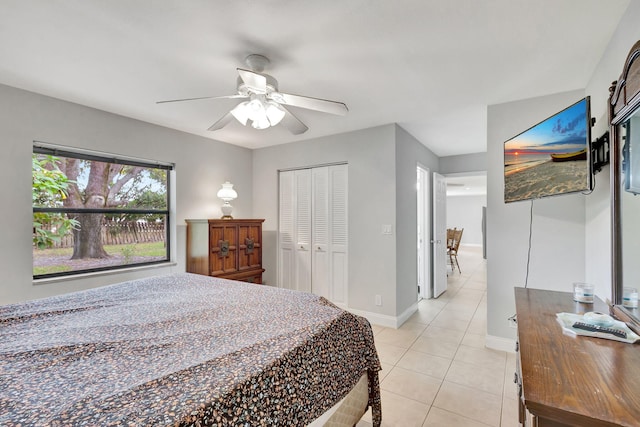 bedroom with ceiling fan, light tile patterned floors, and a closet