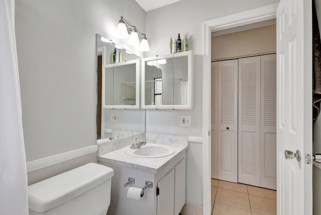 bathroom with toilet, tile patterned flooring, and vanity