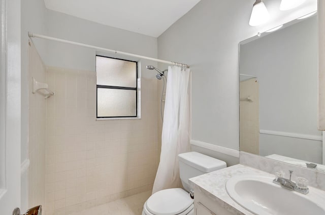 bathroom featuring toilet, a shower with shower curtain, and vanity