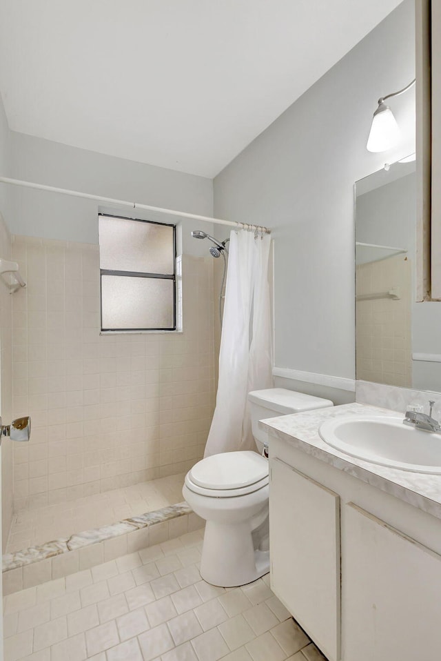 bathroom featuring walk in shower, vanity, tile patterned floors, and toilet