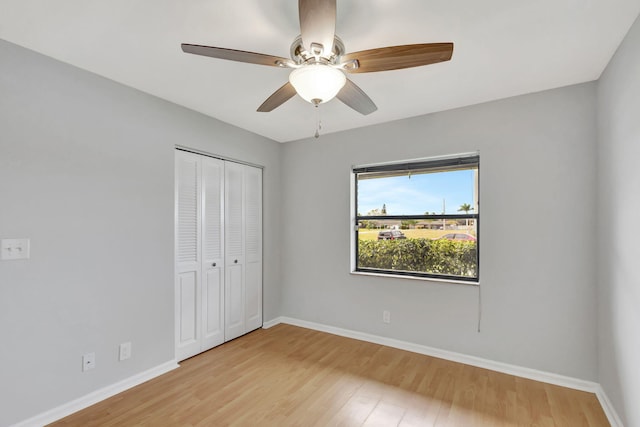 unfurnished bedroom with ceiling fan, a closet, and light hardwood / wood-style flooring