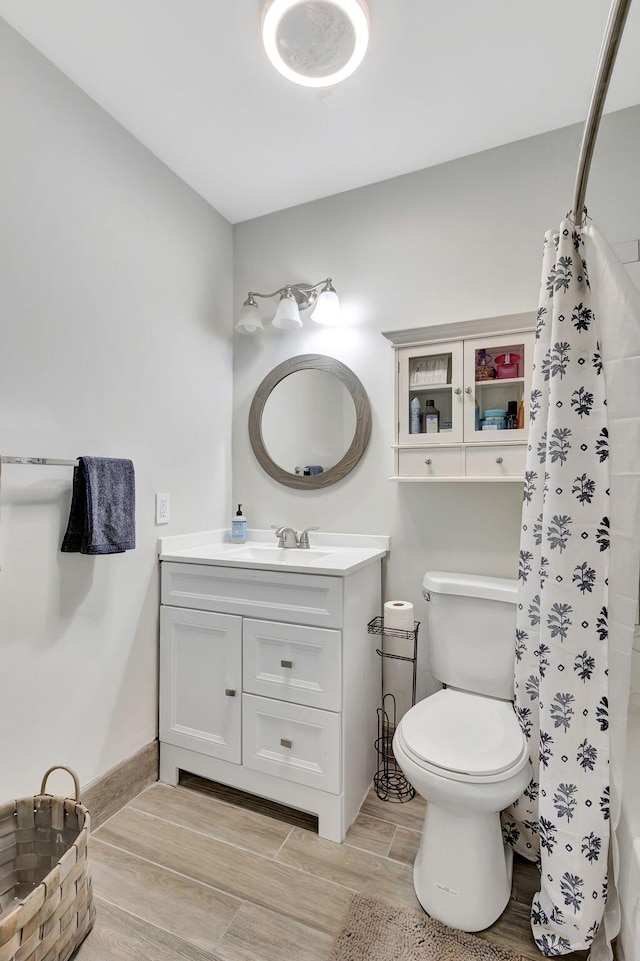 bathroom with toilet, walk in shower, and vanity