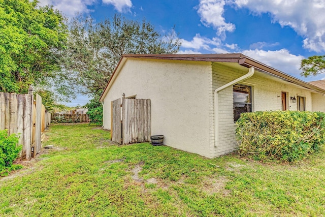 view of side of home with a yard