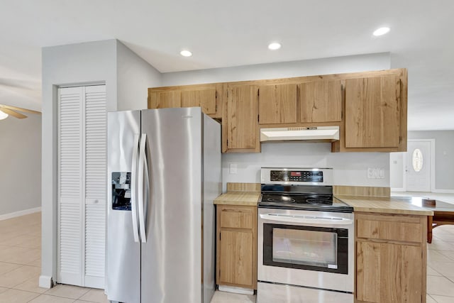 kitchen featuring light tile patterned flooring, ceiling fan, and appliances with stainless steel finishes