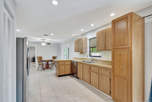 kitchen with light tile patterned floors, ceiling fan, stainless steel appliances, light brown cabinetry, and sink