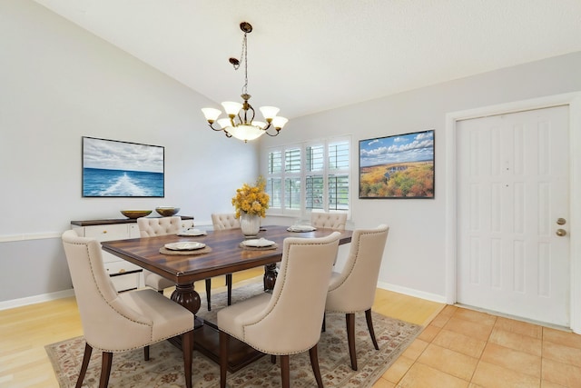 dining room with lofted ceiling and a chandelier