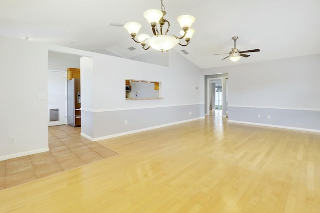 unfurnished room featuring ceiling fan with notable chandelier, sink, light wood-type flooring, and vaulted ceiling