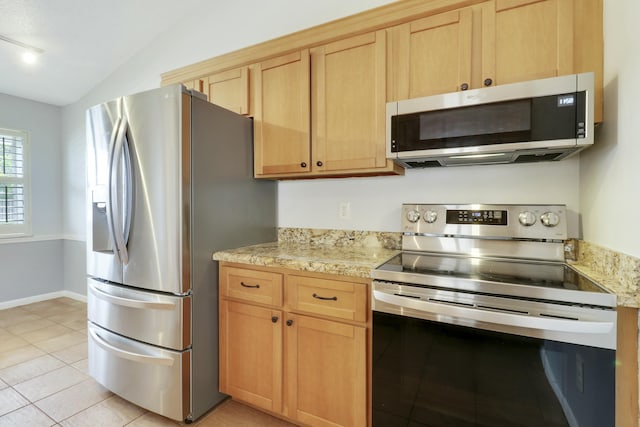 kitchen featuring lofted ceiling, light brown cabinetry, light tile patterned floors, and appliances with stainless steel finishes