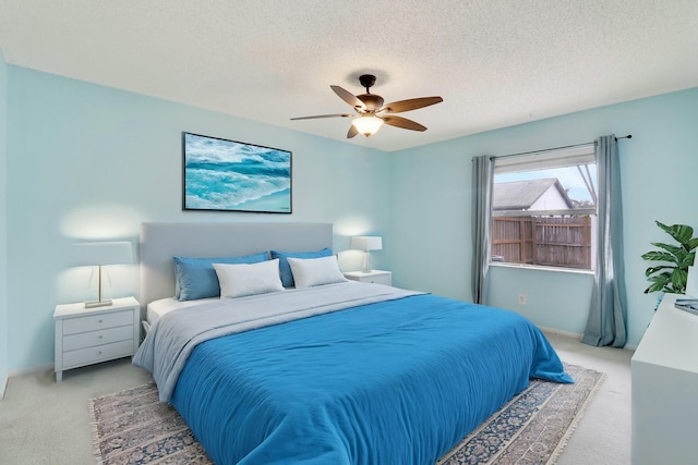 bedroom with a textured ceiling, ceiling fan, and carpet flooring