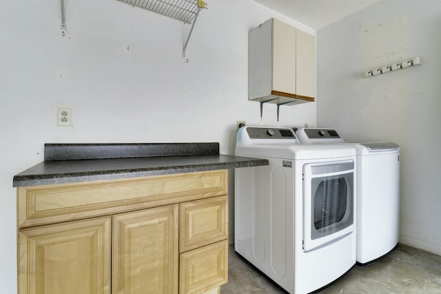 clothes washing area featuring independent washer and dryer, a textured ceiling, and cabinets