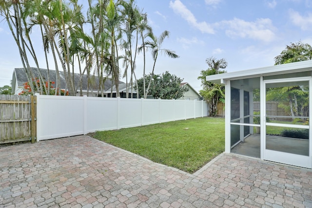 view of yard with a sunroom and a patio