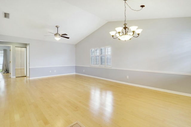 unfurnished room featuring ceiling fan with notable chandelier, light wood-type flooring, and vaulted ceiling