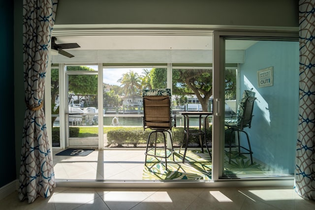 sunroom featuring a water view and ceiling fan