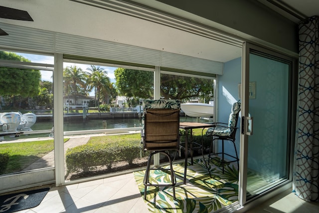 sunroom featuring a water view