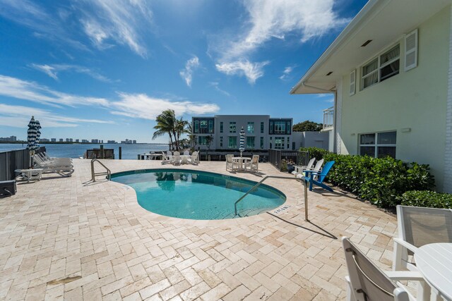 view of pool featuring a patio and a water view