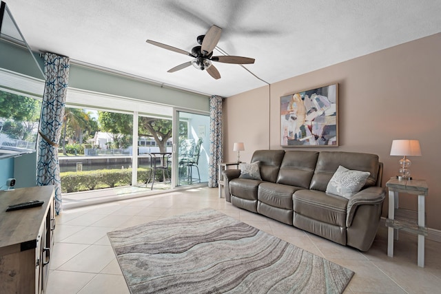 tiled living room featuring ceiling fan and a textured ceiling