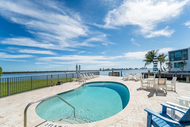 view of swimming pool with a patio and a water view