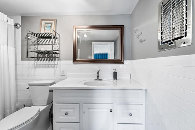 bathroom featuring vanity, tile walls, and toilet