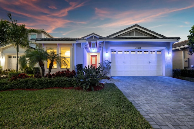 view of front of property with a garage and a lawn