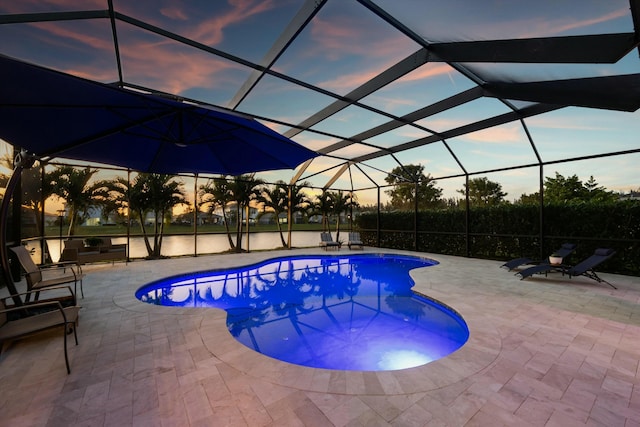 pool at dusk with a lanai and a patio