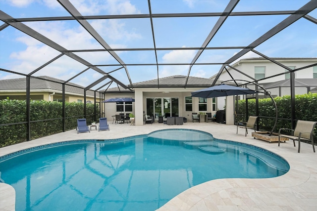 view of pool with glass enclosure, a patio area, an outdoor hangout area, and ceiling fan