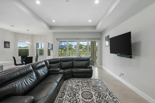 living room with a healthy amount of sunlight, light tile patterned floors, and an inviting chandelier