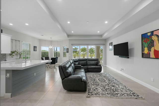 living room with sink and a tray ceiling