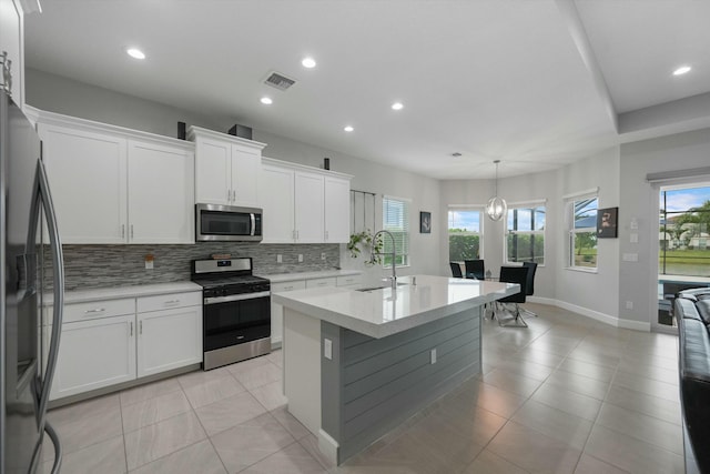 kitchen with white cabinetry, stainless steel appliances, a healthy amount of sunlight, sink, and hanging light fixtures