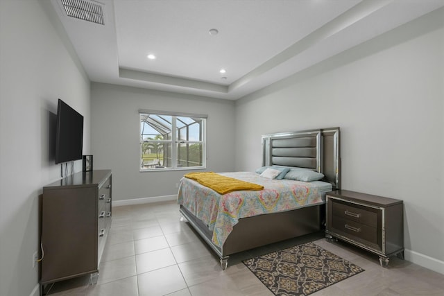 tiled bedroom featuring a raised ceiling