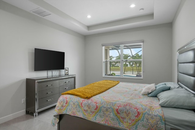 bedroom featuring light tile patterned floors and a raised ceiling