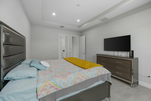 bedroom featuring light tile patterned flooring and a raised ceiling