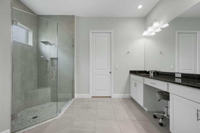 bathroom with a shower with shower door, vanity, and tile patterned flooring