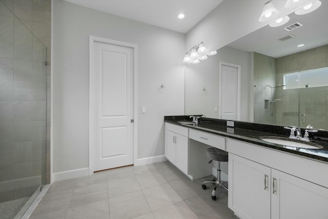 bathroom with a shower with shower door, tile patterned floors, and vanity