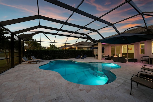 pool at dusk with a lanai, an outdoor living space, and a patio area