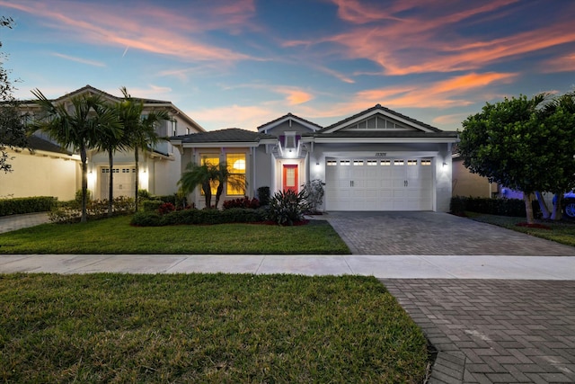 view of front of house featuring a garage and a lawn